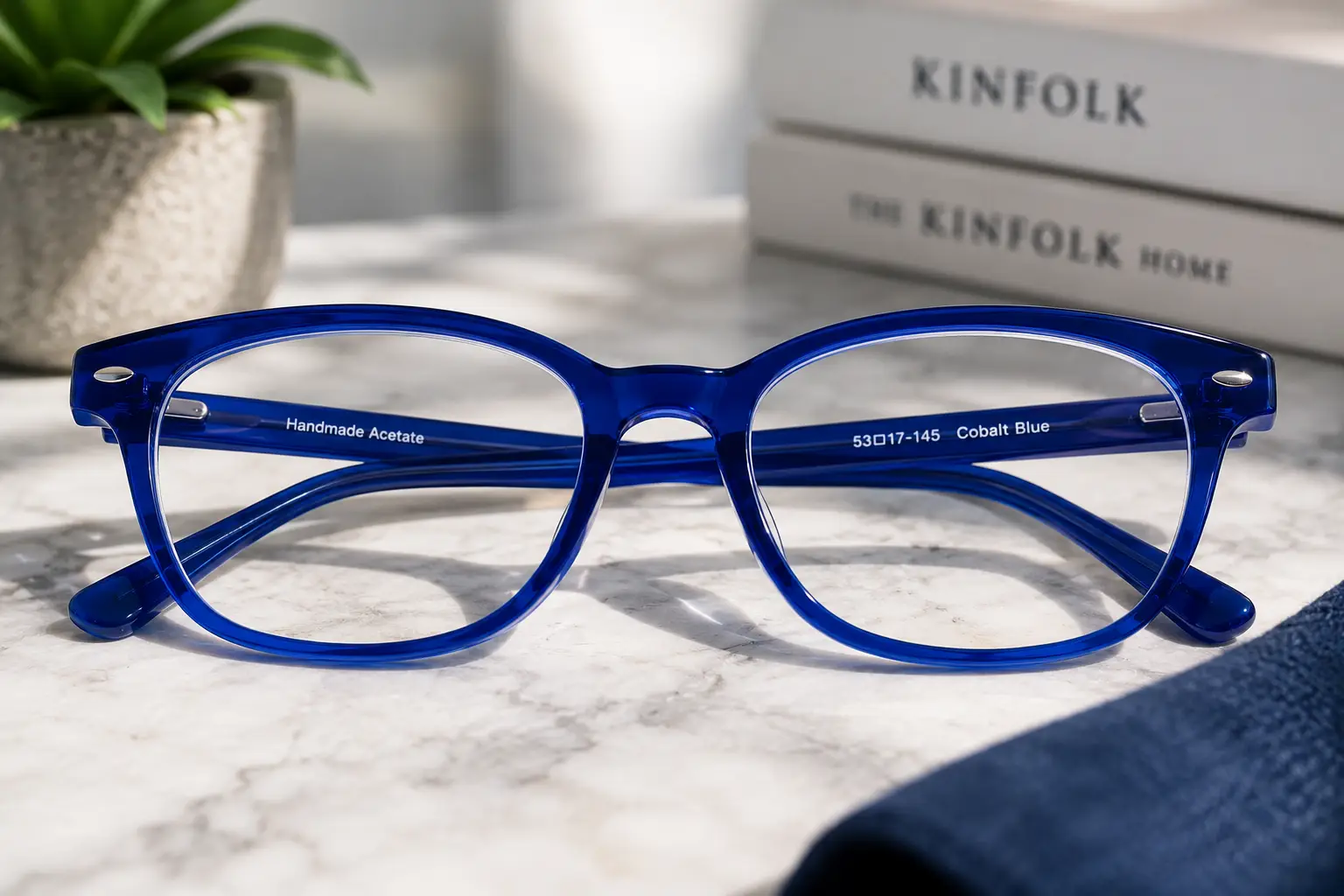 Glossy cobalt blue eyeglass frames with clear lenses in a modern setting